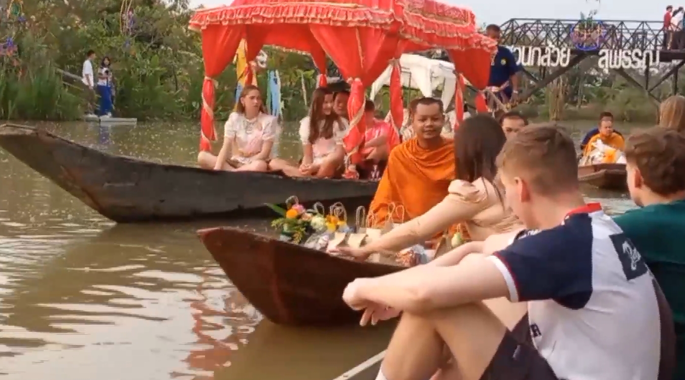 สุพรรณบุรี-นักท่องเที่ยวต่างชาติแต่งชุดไทยร่วมสืบสานประเพณีตักบาตรทางน้ำ